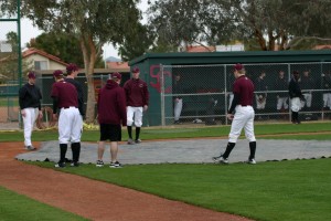 Swat players help tarp the field on Sunday's rain out.