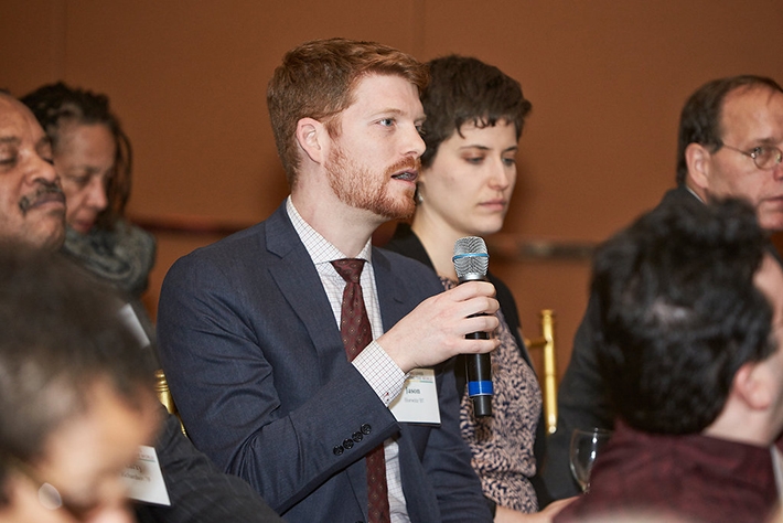 A young alumnus asks a question of President Smith.